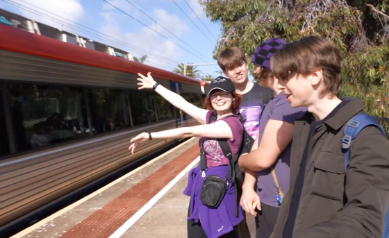 A group of players posing next to an approaching train