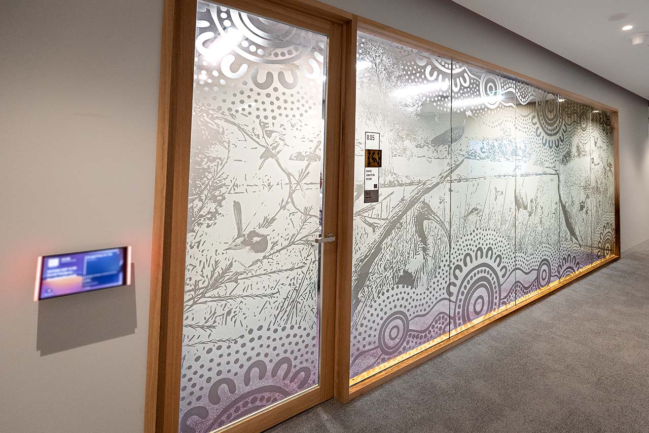 Artwotk on the glass walls of meeting rooms depicting the Lakes/Rivers theme.