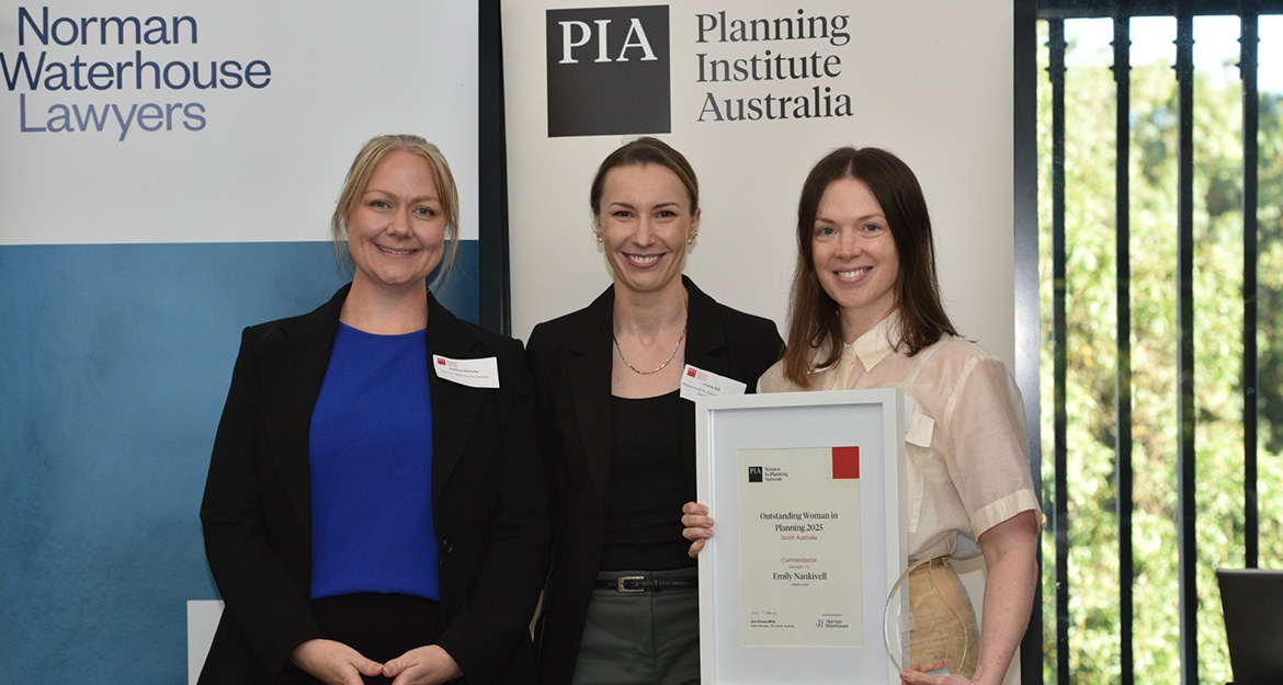 three professional women holding a certificate and trophy
