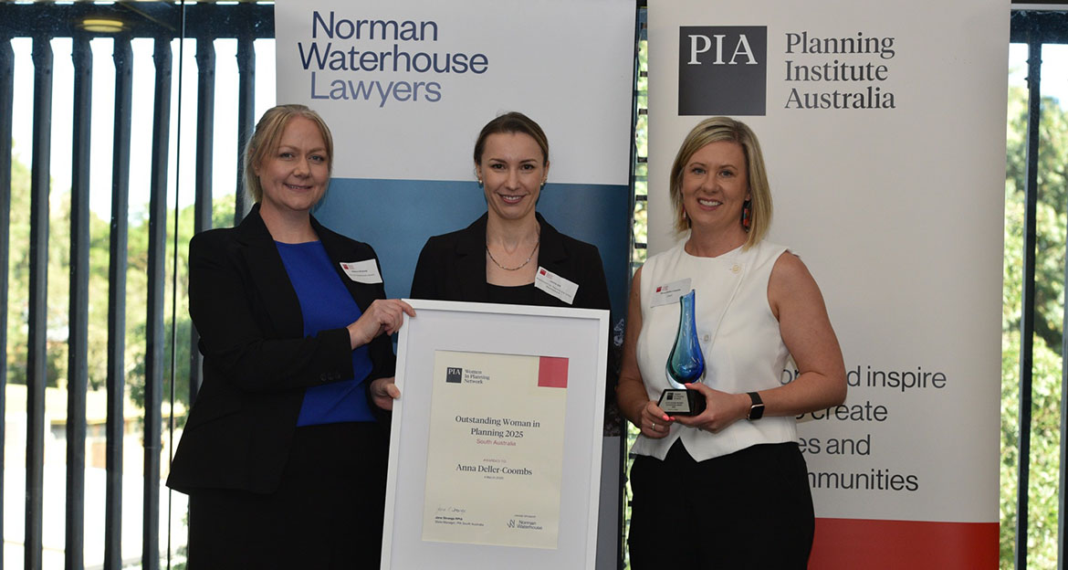 three professional women holding a certificate and trophy